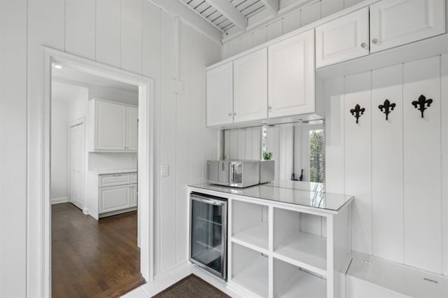 bar featuring beamed ceiling, dark wood-type flooring, and wine cooler