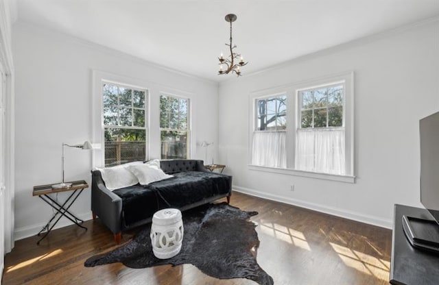 sitting room with baseboards, an inviting chandelier, and crown molding