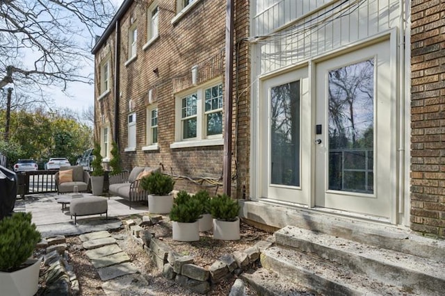 view of property exterior featuring brick siding, a patio area, and entry steps
