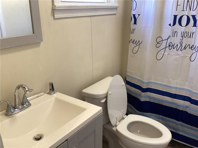 bathroom featuring a shower with curtain, vanity, and toilet