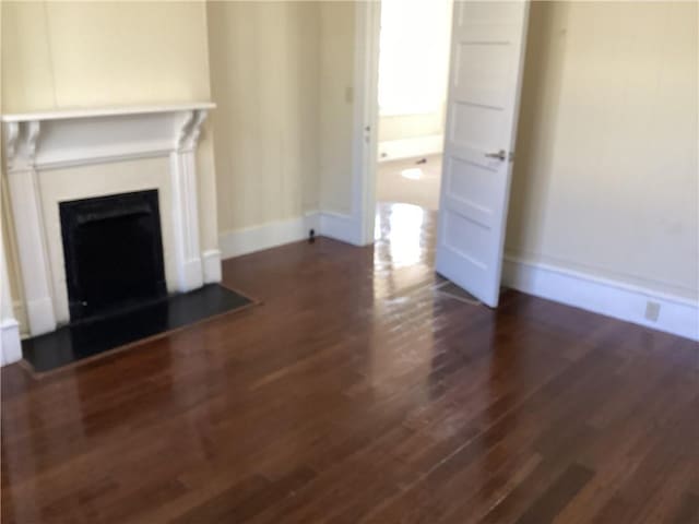 unfurnished living room with dark wood-type flooring