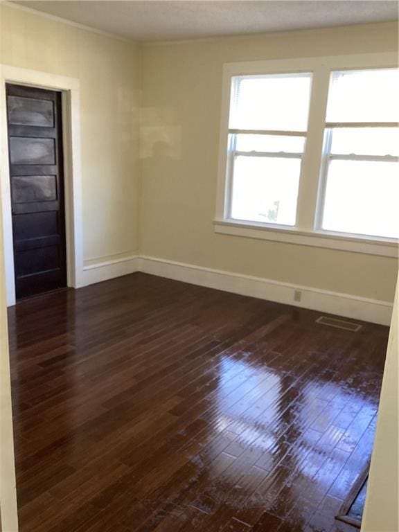 unfurnished room with dark wood-type flooring and ornamental molding