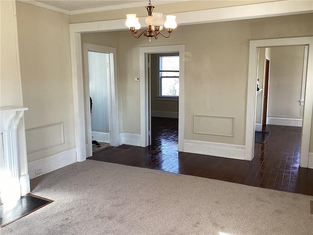 unfurnished dining area featuring an inviting chandelier, dark carpet, and crown molding