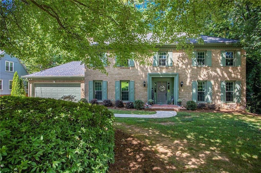 2982 Huntshire Pl, Atlanta, GA 30340 - colonial home with an attached garage, a front yard, and brick siding