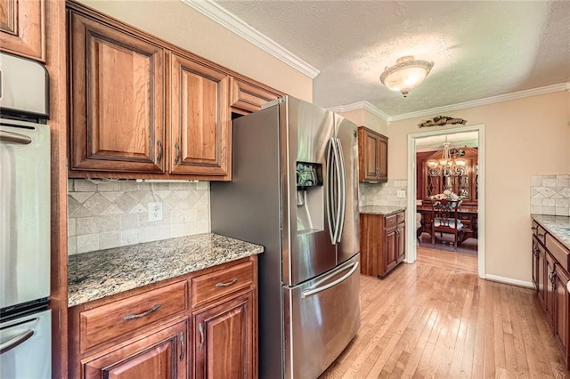 3592 Midvale Cv, Tucker, GA 30084 - kitchen with stainless steel appliances, brown cabinets, tasteful backsplash, light wood-style floors, and light stone counters