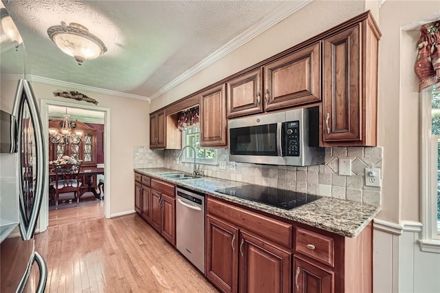 3592 Midvale Cv, Tucker, GA 30084 - kitchen with appliances with stainless steel finishes, a sink, light wood-style floors, a textured ceiling, and a chandelier