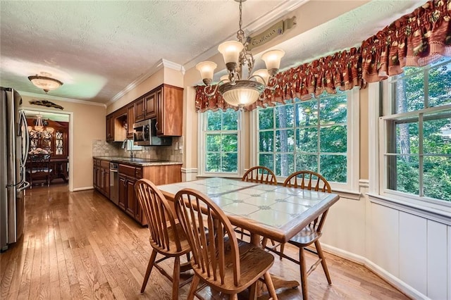 3592 Midvale Cv, Tucker, GA 30084 - dining area featuring a textured ceiling, a chandelier, plenty of natural light, light wood-style floors, and ornamental molding