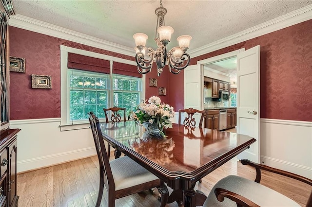 3592 Midvale Cv, Tucker, GA 30084 - dining room featuring a chandelier, wainscoting, light wood finished floors, a textured ceiling, and crown molding
