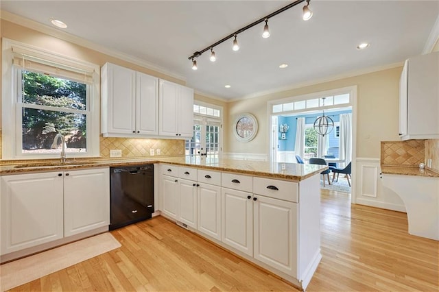 kitchen with a healthy amount of sunlight, black dishwasher, sink, kitchen peninsula, and white cabinetry