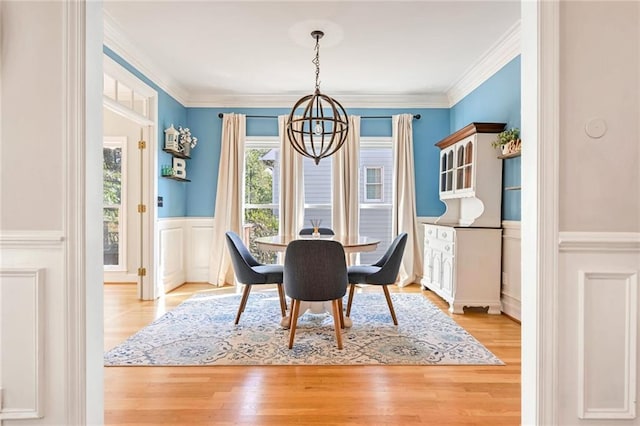 dining room featuring an inviting chandelier, light hardwood / wood-style flooring, and ornamental molding