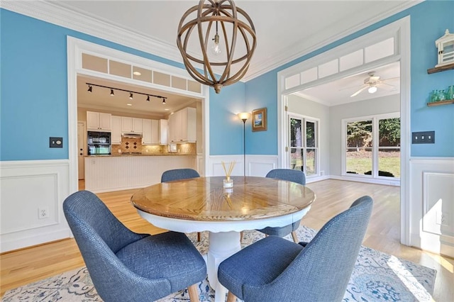 dining room with ornamental molding, light wood-type flooring, and ceiling fan