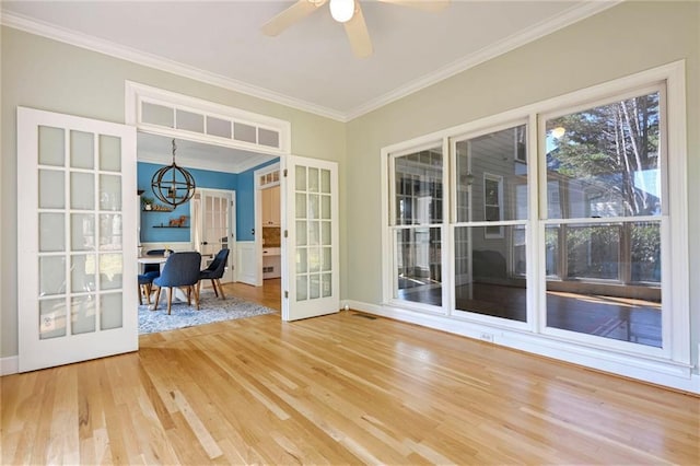 unfurnished sunroom featuring french doors and ceiling fan with notable chandelier