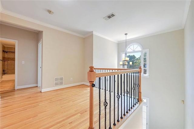 hallway with ornamental molding, a chandelier, and wood-type flooring