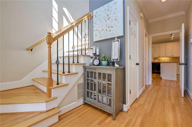 stairs with crown molding and hardwood / wood-style flooring