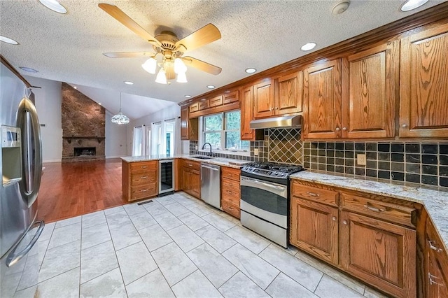 3601 Club Dr NW, Kennesaw, GA 30144 - kitchen featuring stainless steel appliances, wine cooler, a sink, under cabinet range hood, and brown cabinets