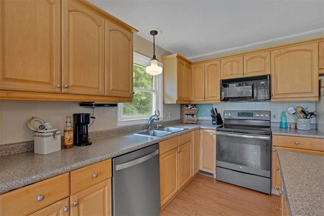 kitchen featuring appliances with stainless steel finishes, sink, hanging light fixtures, light brown cabinets, and light wood-type flooring