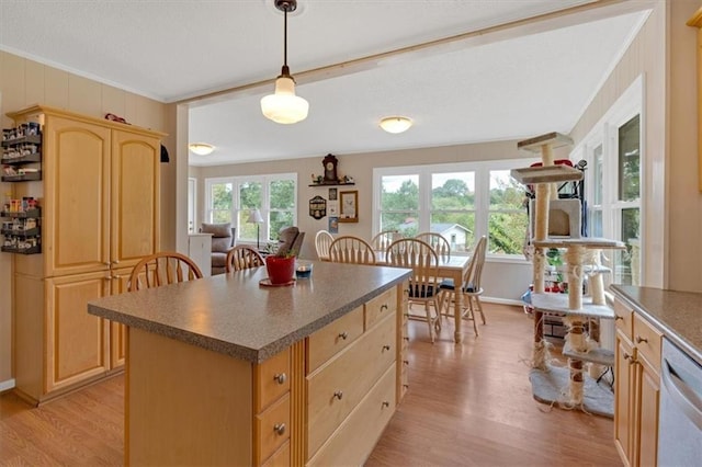 kitchen with a kitchen island, decorative light fixtures, dishwasher, light hardwood / wood-style floors, and crown molding