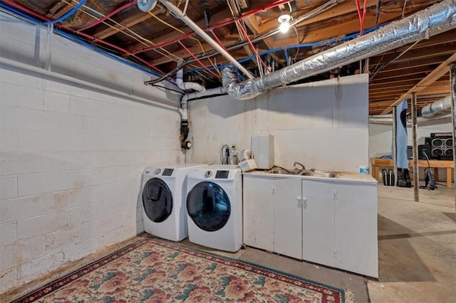 laundry area featuring cabinets, sink, and washing machine and clothes dryer