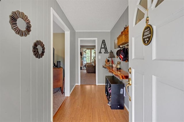 hall with light hardwood / wood-style floors and a textured ceiling