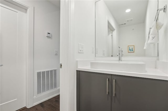 bathroom with recessed lighting, visible vents, wood finished floors, and vanity