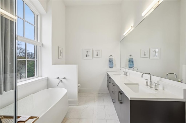 bathroom featuring marble finish floor, plenty of natural light, and a sink