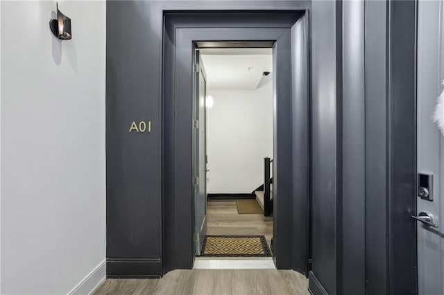 staircase featuring baseboards and wood finished floors