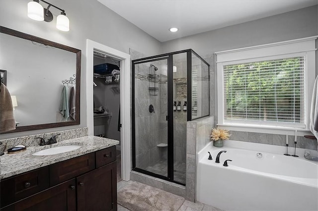 2103 Sourwood Ct, Monroe, GA 30656 - full bathroom featuring a bath, a stall shower, a walk in closet, and vanity