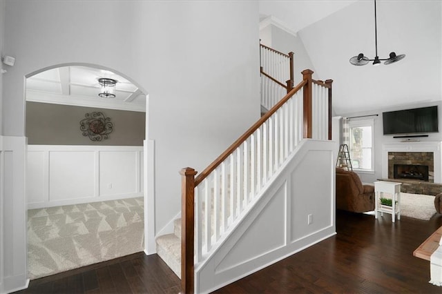 2103 Sourwood Ct, Monroe, GA 30656 - staircase featuring hardwood / wood-style flooring, a decorative wall, ornamental molding, arched walkways, and coffered ceiling