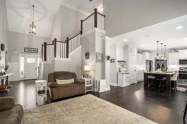 2103 Sourwood Ct, Monroe, GA 30656 - living area with high vaulted ceiling, dark wood finished floors, stairway, and recessed lighting
