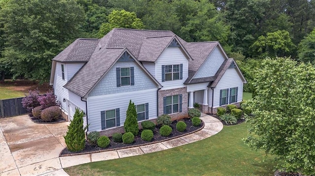 2103 Sourwood Ct, Monroe, GA 30656 - craftsman-style home with driveway, a front yard, a garage, brick siding, and a view of trees