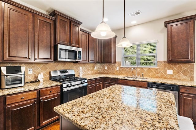 7946 White Oak Loop, Stonecrest, GA 30038 - kitchen featuring appliances with stainless steel finishes, a sink, light stone counters, pendant lighting, and dark brown cabinetry