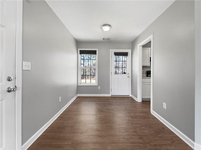 foyer featuring dark wood finished floors, visible vents, and baseboards