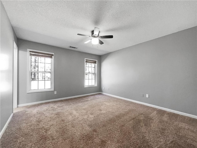 unfurnished room featuring visible vents, ceiling fan, baseboards, carpet, and a textured ceiling