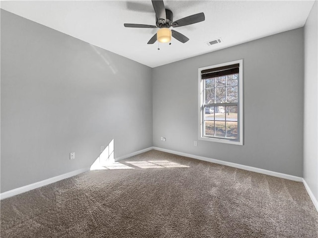 unfurnished room with visible vents, carpet floors, baseboards, and ceiling fan