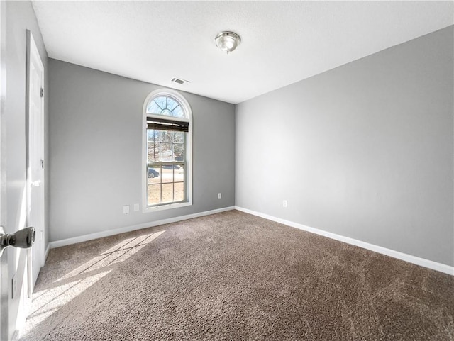 unfurnished room featuring carpet flooring, visible vents, and baseboards