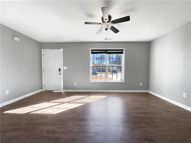 spare room featuring ceiling fan, a textured ceiling, baseboards, and wood finished floors