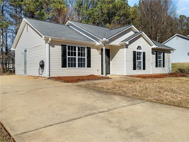 single story home with roof with shingles and driveway