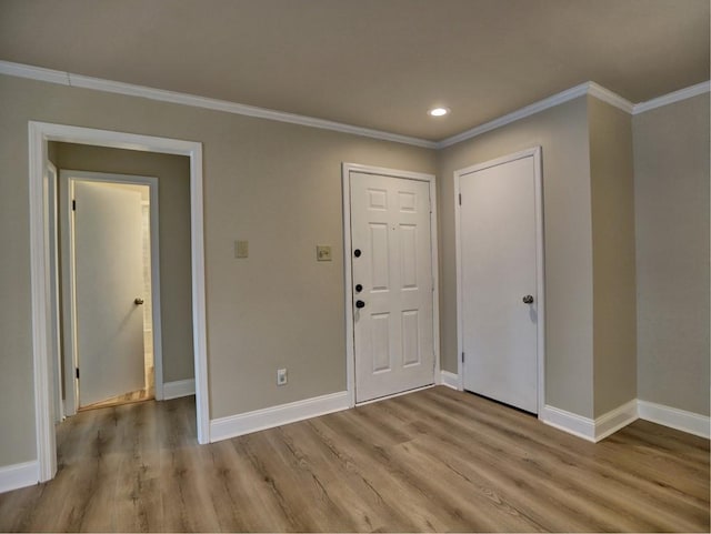 entryway featuring ornamental molding and light hardwood / wood-style floors