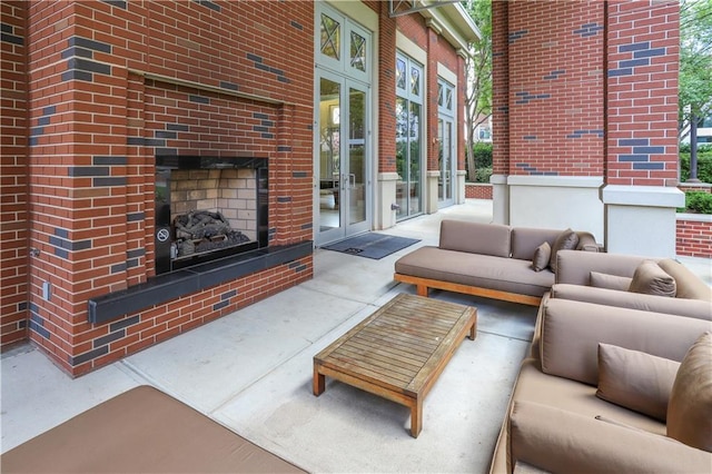 living area featuring concrete flooring, an outdoor brick fireplace, and plenty of natural light