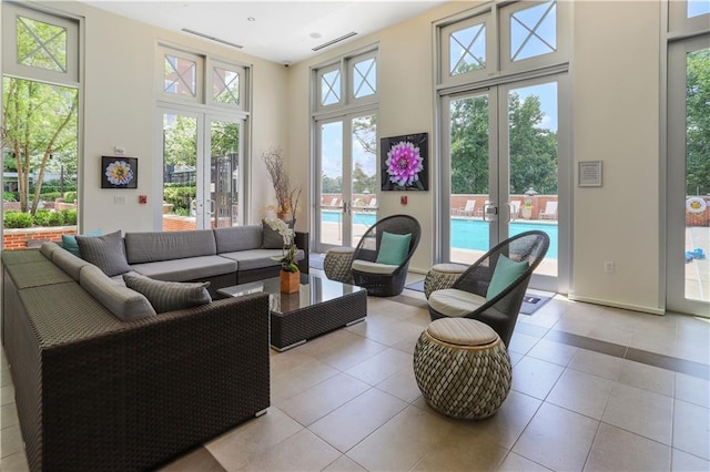 living room featuring visible vents, a high ceiling, and tile patterned flooring