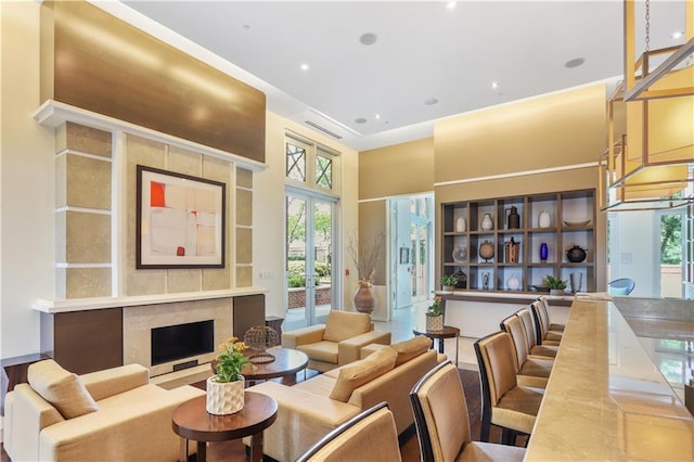 living room with a towering ceiling, a fireplace, and visible vents