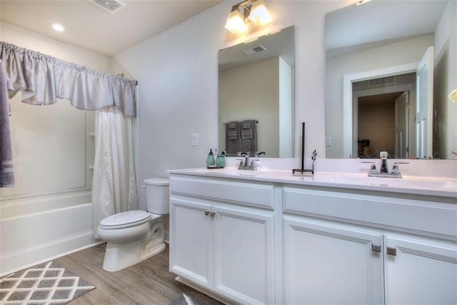 full bathroom featuring wood-type flooring, toilet, shower / tub combo with curtain, and vanity