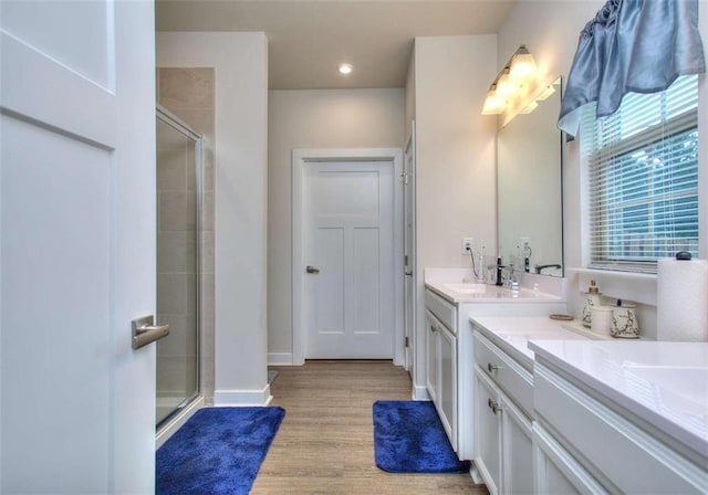 bathroom with vanity, a shower with door, and hardwood / wood-style floors