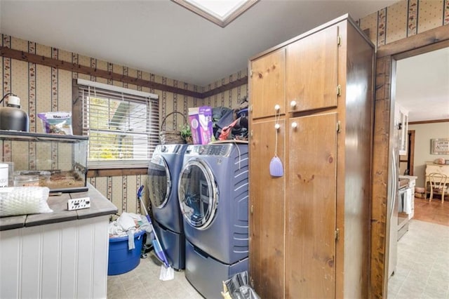 clothes washing area with cabinets and separate washer and dryer