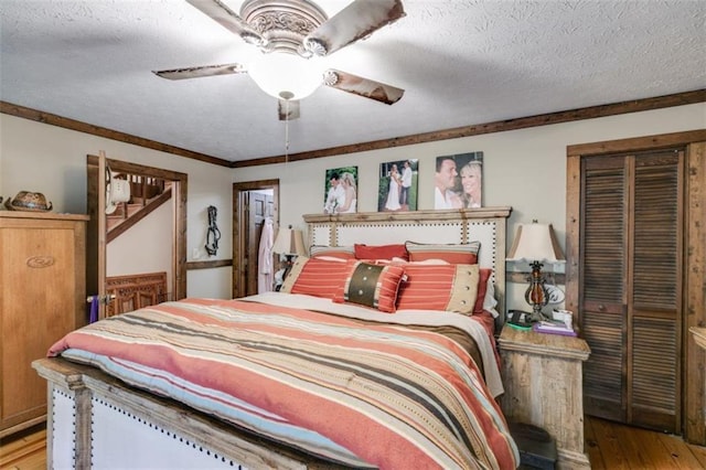 bedroom featuring hardwood / wood-style floors, a textured ceiling, ceiling fan, and crown molding