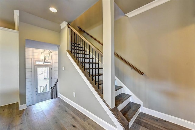 entryway featuring hardwood / wood-style floors, baseboards, and stairs