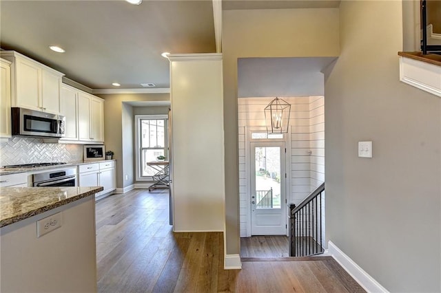 kitchen with baseboards, white cabinetry, light stone countertops, light wood-style flooring, and stainless steel appliances