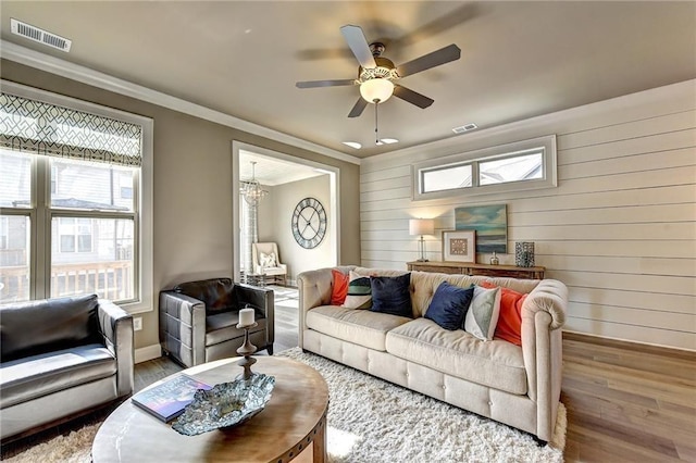 living area with visible vents, baseboards, and wood finished floors