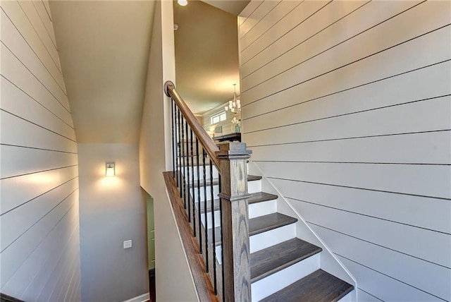 staircase with wood walls and baseboards