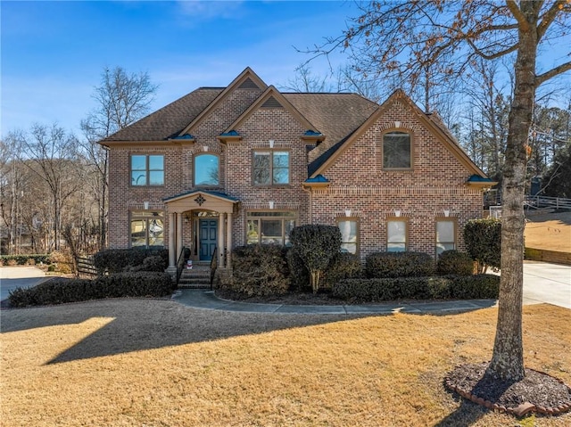 traditional-style house featuring brick siding and a front yard